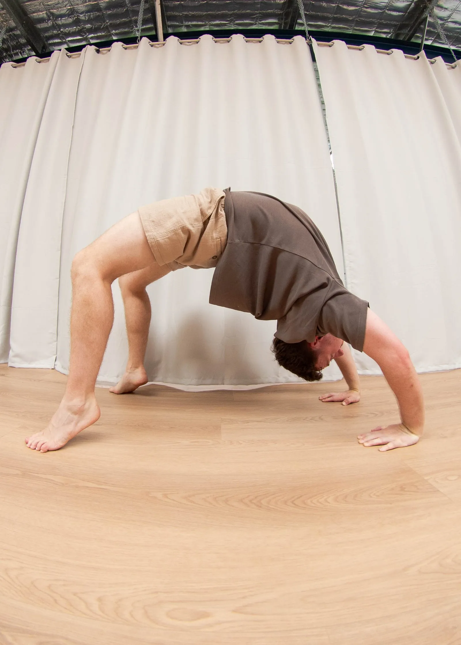Keegan in a bridge position, hands and feet on the floor and hips lifted, demonstrating shoulder and spine extension